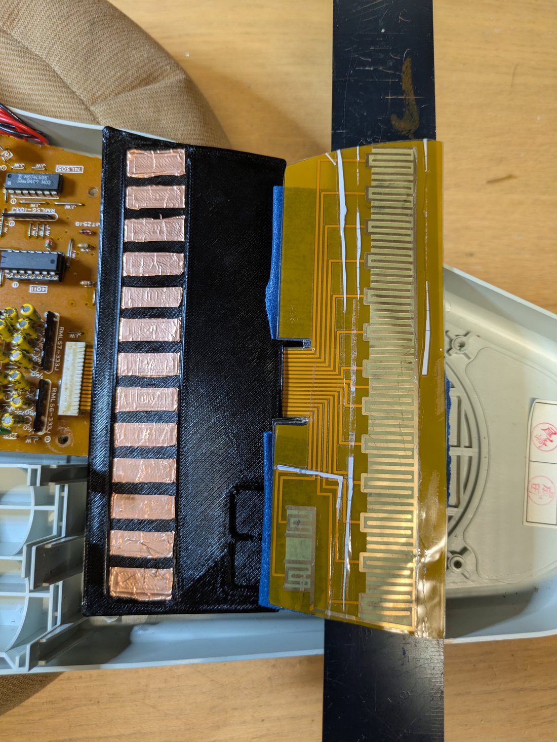 Omnichord flex PCB strumplate next to a 3D printed top plate with segmented conductive sections